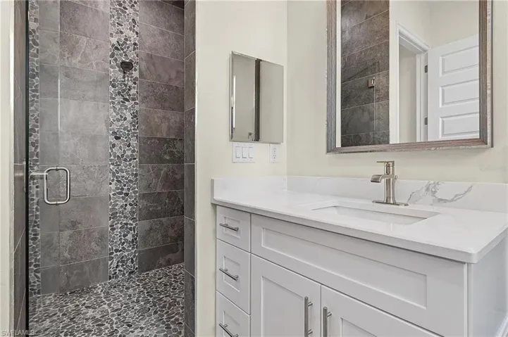 Bathroom with a shower with shower door and vanity