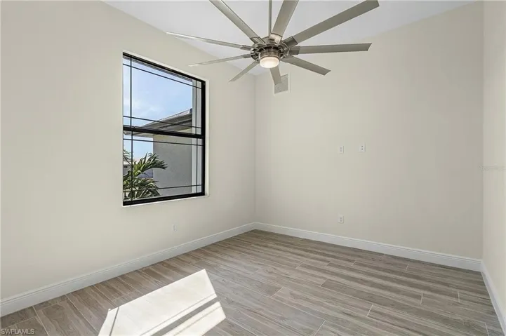 Empty room featuring light wood-type flooring and ceiling fan