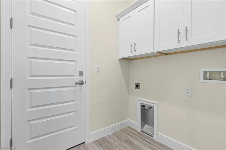 Washroom featuring electric dryer hookup, light hardwood / wood-style flooring, cabinets, and hookup for a washing machine