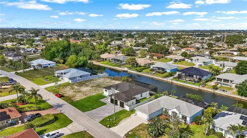 Expansive cleared lot with lush green grass bordering an established residential street