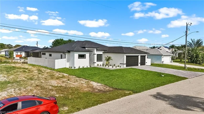Contemporary single-story exterior featuring a white stucco facade, black trim accents, a dark shingle roof, and a meticulously manicured front lawn