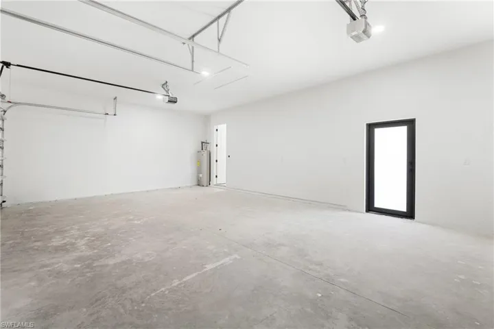 Spacious garage with concrete flooring, white painted walls, and overhead lighting