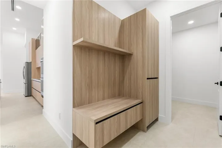 Built-in wood-finish cabinetry featuring open shelving and integrated seating