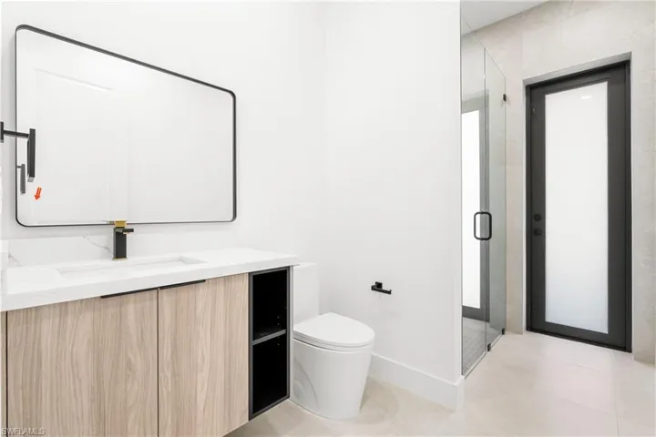 Modern bathroom featuring a wood-finish vanity with a white countertop and integrated sink