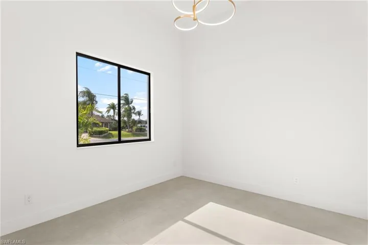 Interior space with light-toned flooring, white walls, and a modern ceiling fixture