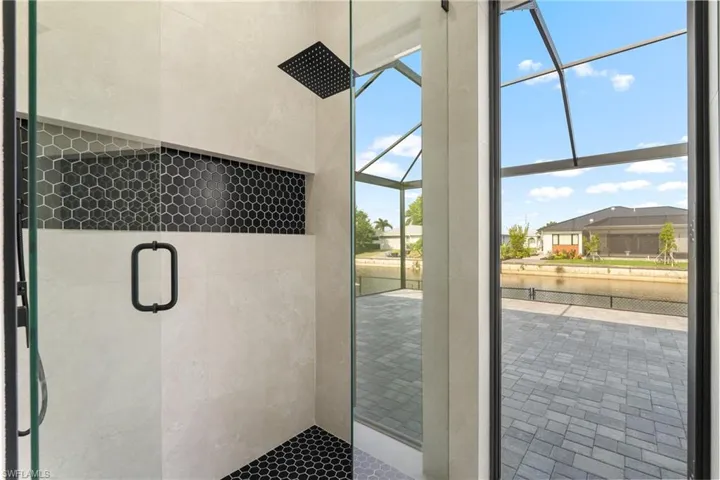 Glass-enclosed shower with a matte black rainfall showerhead