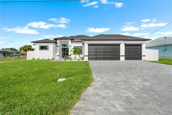 Modern single-story residence featuring a white stucco exterior with dark trim accents