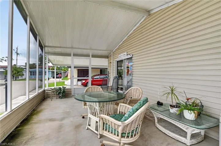 Enclosed patio with full-height screening, concrete flooring, and an exterior wall featuring horizontal siding
