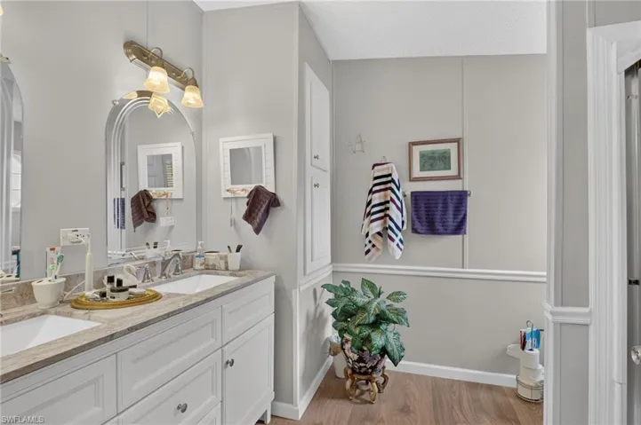 Dual vanity with integrated sinks, light-toned countertop, and white cabinetry