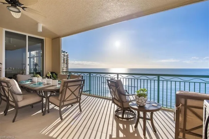 Balcony featuring ceiling fan and a water view