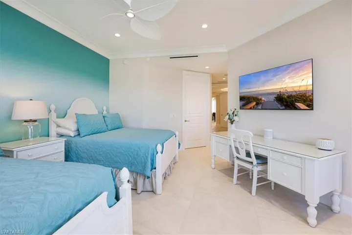 Tiled bedroom featuring ceiling fan and ornamental molding