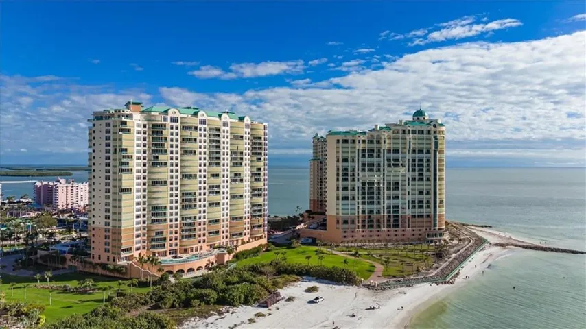 View of building exterior featuring a water view and a beach view