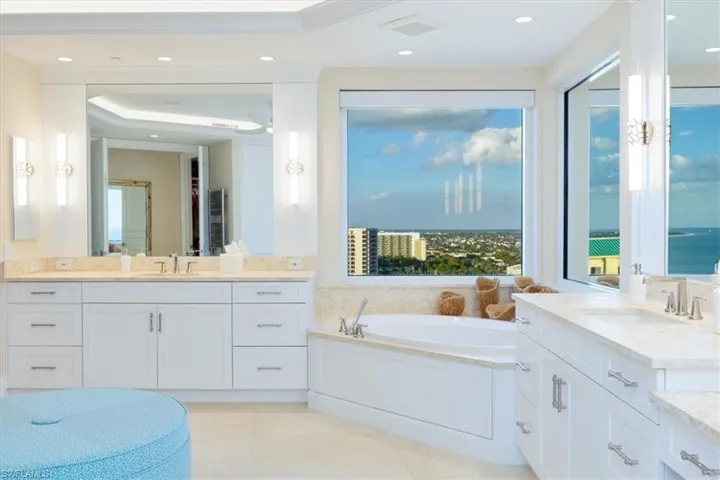 Bathroom featuring tile patterned floors, vanity, a water view, and a washtub