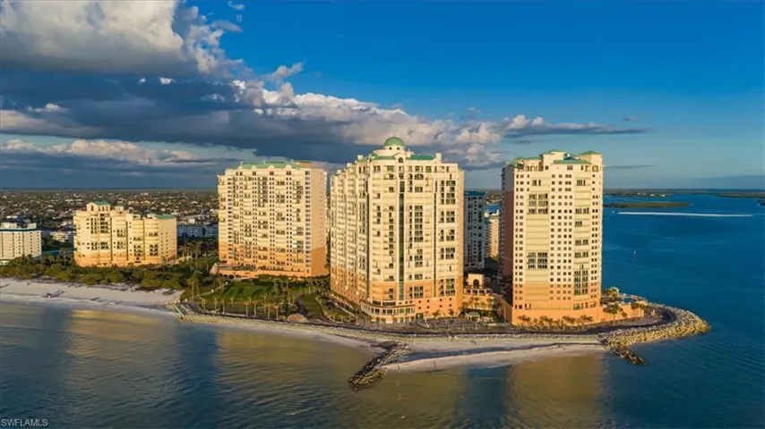 Birds eye view of property featuring a water view and a view of the beach