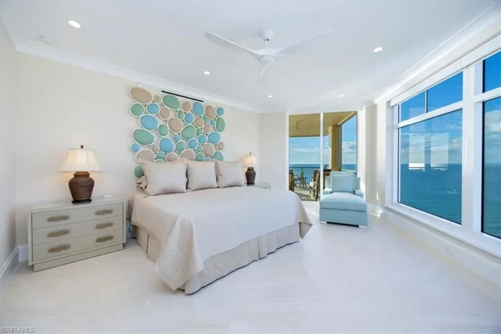 Bedroom with ceiling fan, crown molding, and a water view