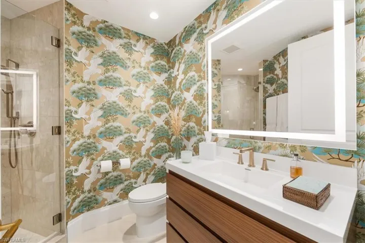 Bathroom with vanity, toilet, and a shower with door