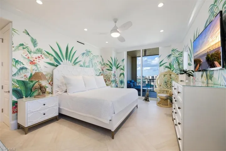Bedroom featuring ceiling fan, access to exterior, ornamental molding, and a wall of windows