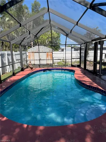 View of pool with a fenced in pool, glass enclosure, and a fenced backyard
