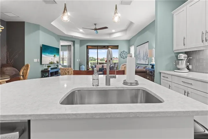 Kitchen island featuring a stainless steel undermount sink and a brushed nickel faucet