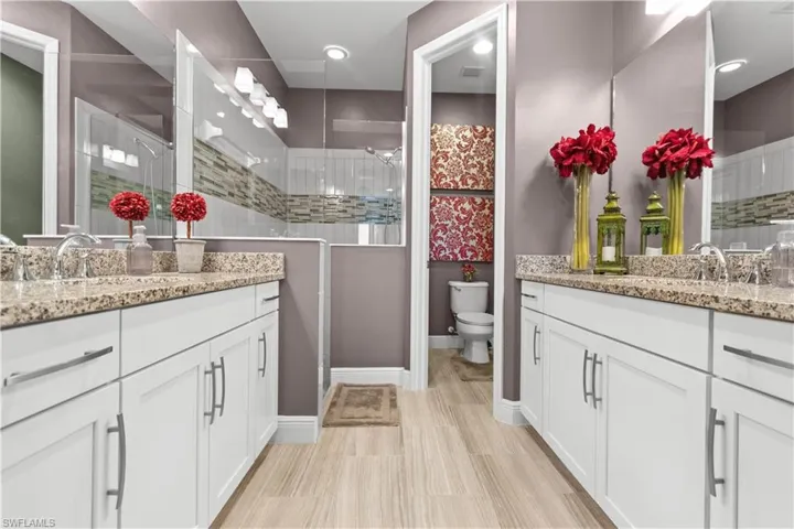 Dual vanities with granite countertops and white cabinetry