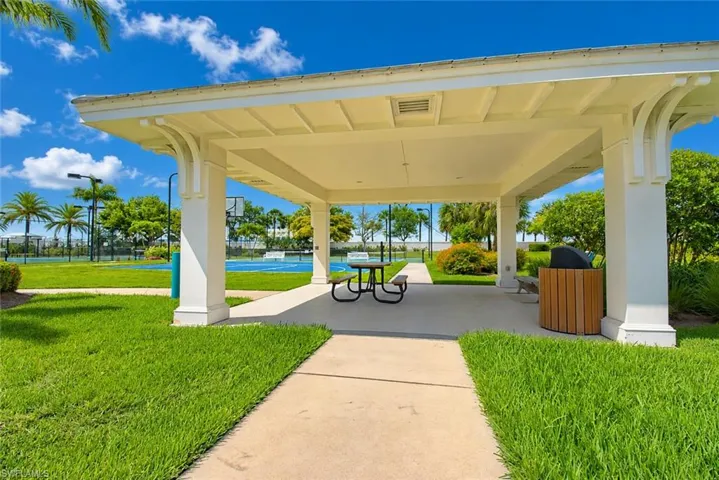 Open-air pavilion featuring a concrete pad, a picnic table, and a built-in outdoor grill