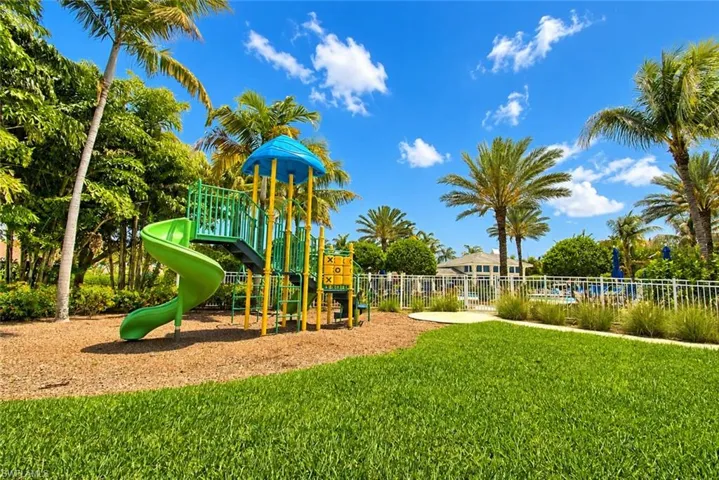 Recreational play structure featuring a green spiral slide and tic-tac-toe panel