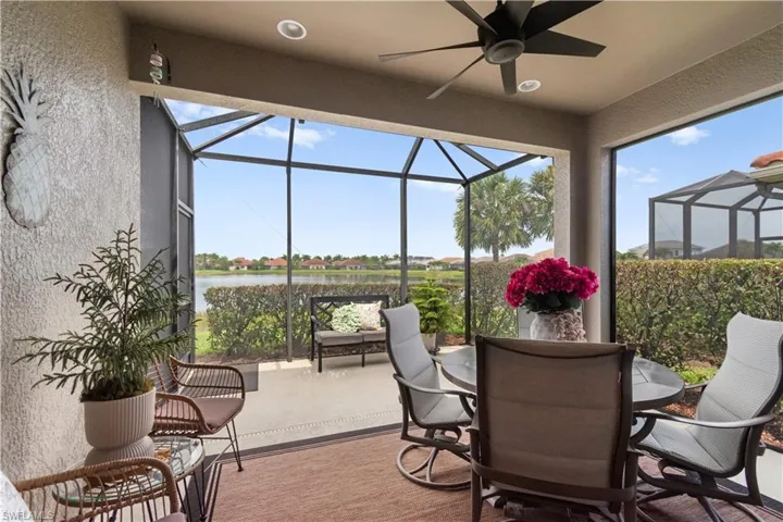 Screened lanai featuring a ceiling fan, recessed lighting, and a water view