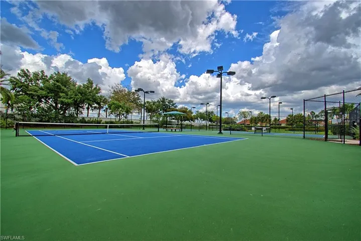 Regulation-size tennis court featuring a blue playing surface and green surrounding court