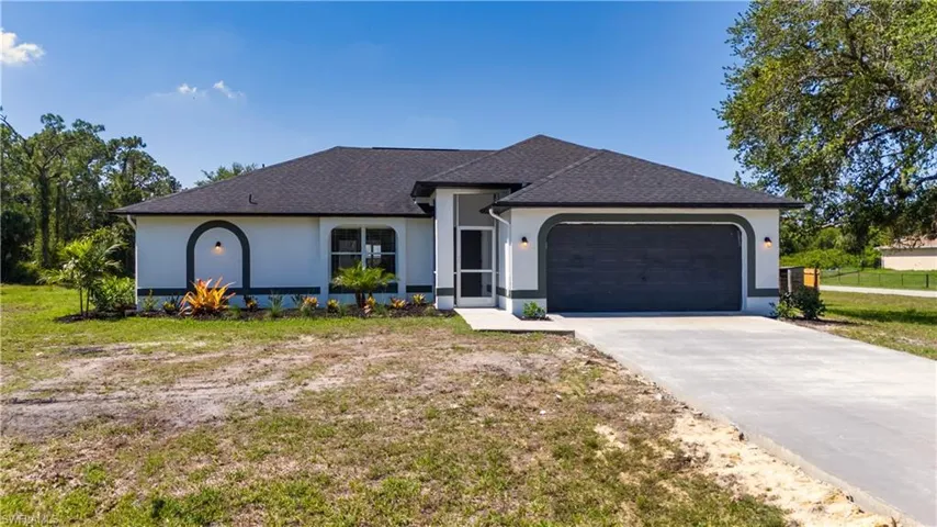 View of front of home featuring stucco siding, an attached garage, driveway, roof with shingles, and a front yard