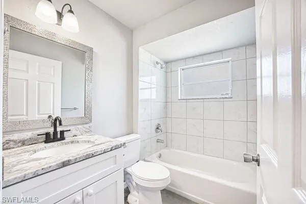 Bathroom with toilet, vanity, and bathing tub / shower combination