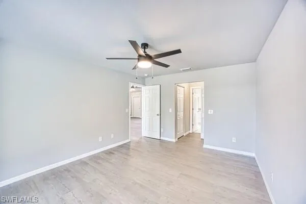 Primary bedroom featuring baseboards, light wood-type flooring, and ceiling fan