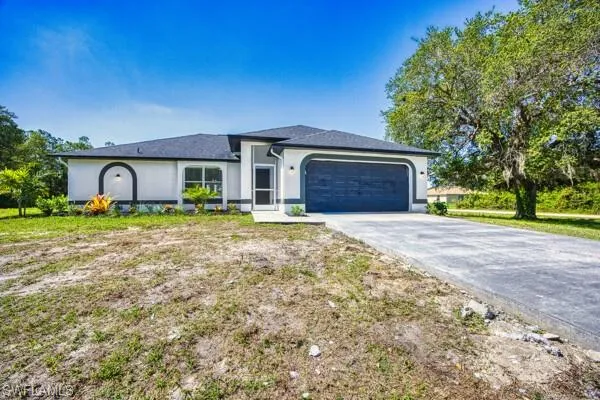 Ranch-style home featuring an attached garage, driveway, and stucco siding