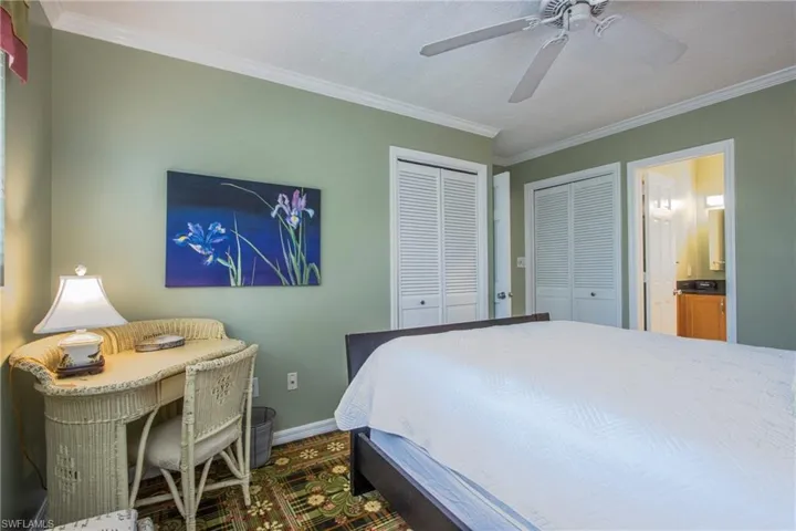 Bedroom featuring multiple closets, crown molding, a textured ceiling, and ceiling fan