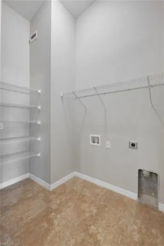 Laundry room with tile patterned floors, hookup for an electric dryer, and washer hookup