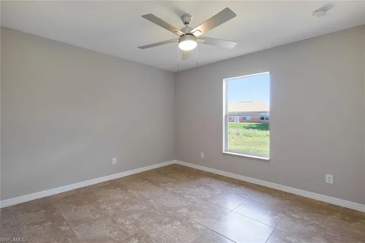 Spare room with ceiling fan and light tile patterned floors
