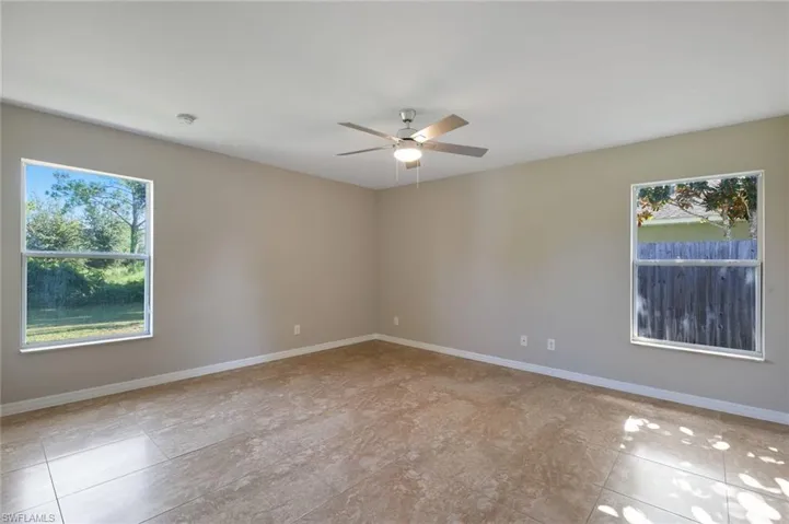 Tiled spare room with ceiling fan
