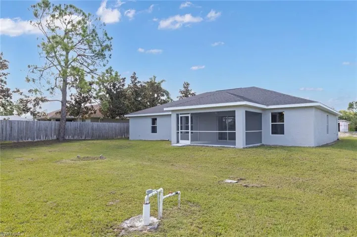 Back of house featuring a yard and a sunroom