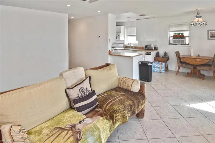 Living area with light tile patterned floors, recessed lighting, and cooling unit