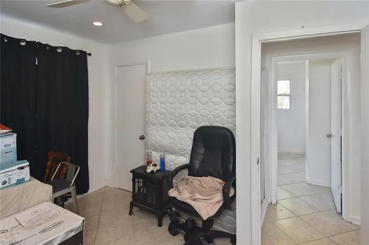 Office area featuring light tile patterned floors and ceiling fan
