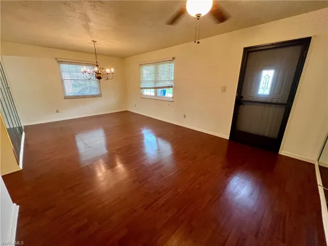 Living room featuring dark hardwood / wood-style floors and ceiling fan with notable chandelier