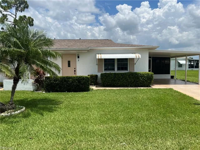 View of front of house with a front lawn and a carport