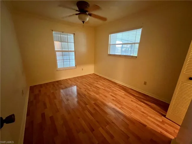 Guest bedroom featuring ceiling fan, hardwood / wood-style flooring, and ornamental molding