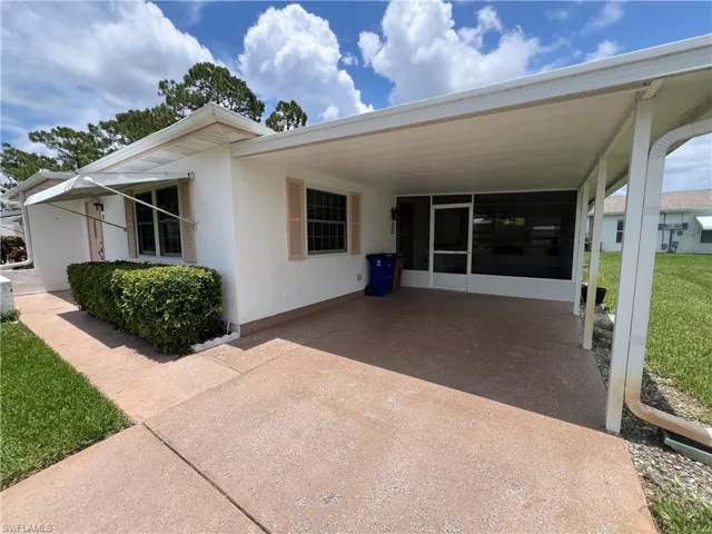View of front of house with a carport and a front lawn