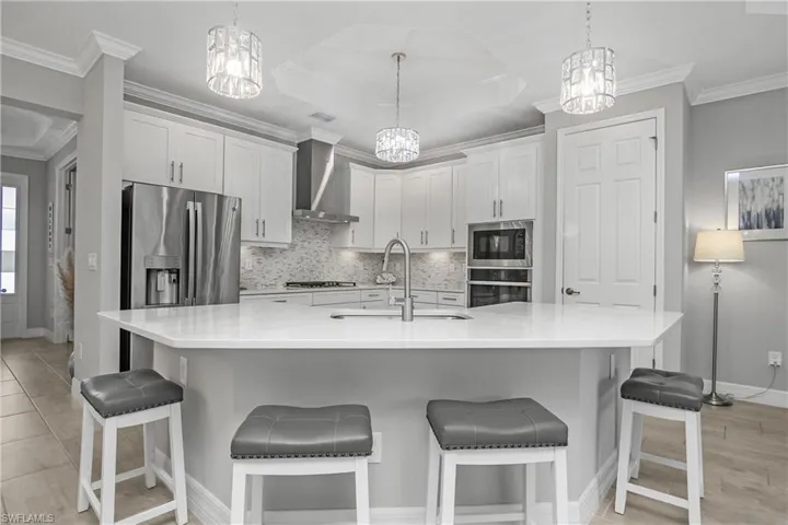 The kitchen is the heart of the home with an oversized island, upgraded cabinetry with pull out drawer, and natural gas stainless steel appliances.