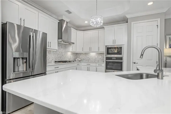 The quartz countertops and custom backsplash really stand out in this open floor plan.