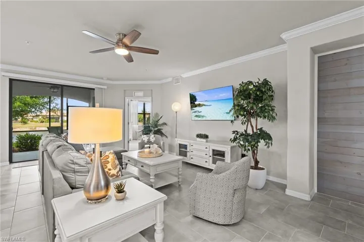 Living room featuring visible vents, crown molding, baseboards, and ceiling fan