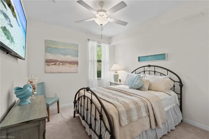 Bedroom featuring light colored carpet, visible vents, and baseboards