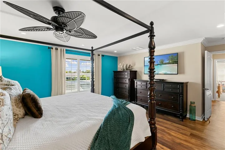 Bedroom with crown molding, wood finished floors, recessed lighting, and a ceiling fan