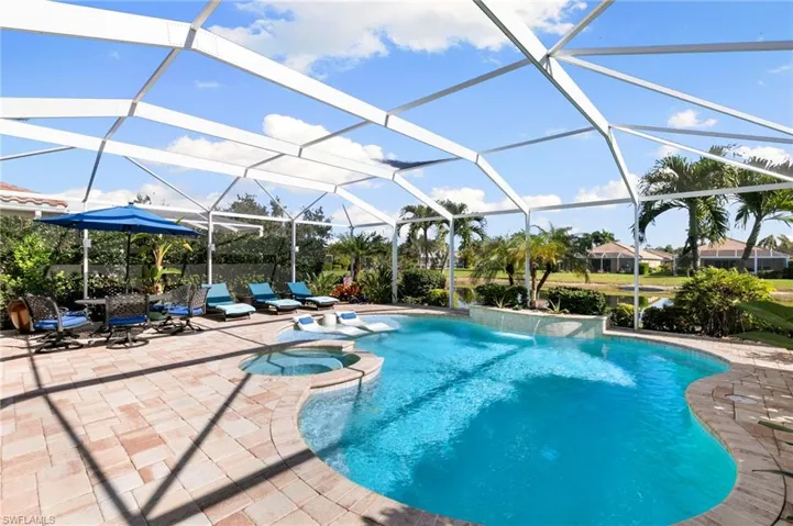 View of pool with a lanai, a pool with connected hot tub, a sunroom, and a patio