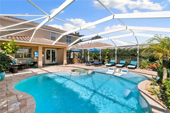 View of swimming pool with a patio area, a sunroom, a HUGE lanai, french doors, and outdoor dining space